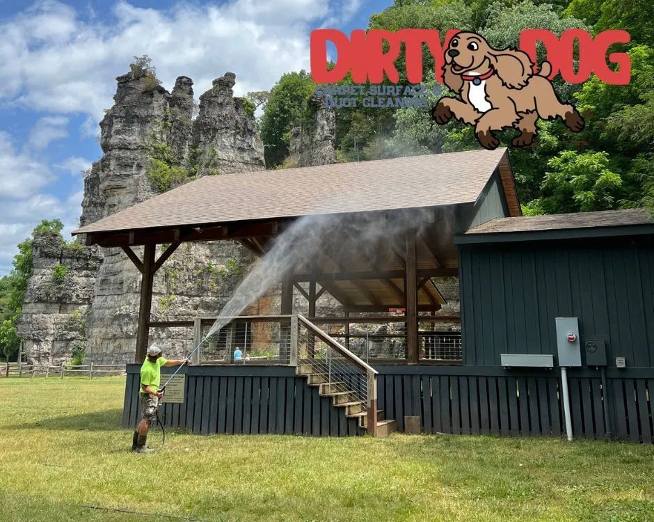 Water spraying onto a small pavilion beside stone ruins, with a Dirty Dog logo in the top right.