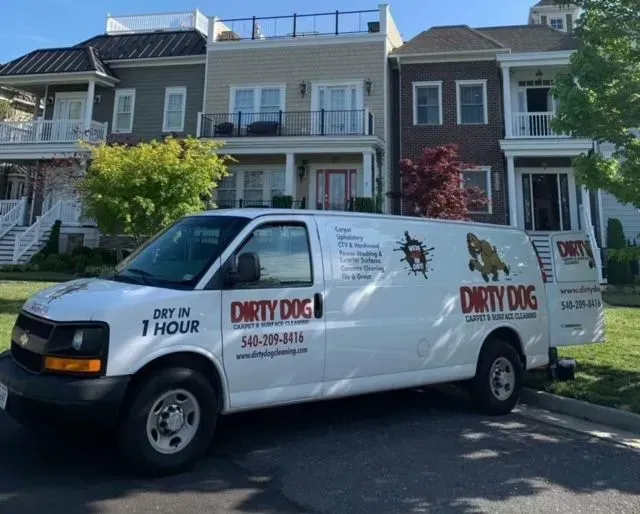 White Dirty Dog service van parked on a residential street in front of houses.