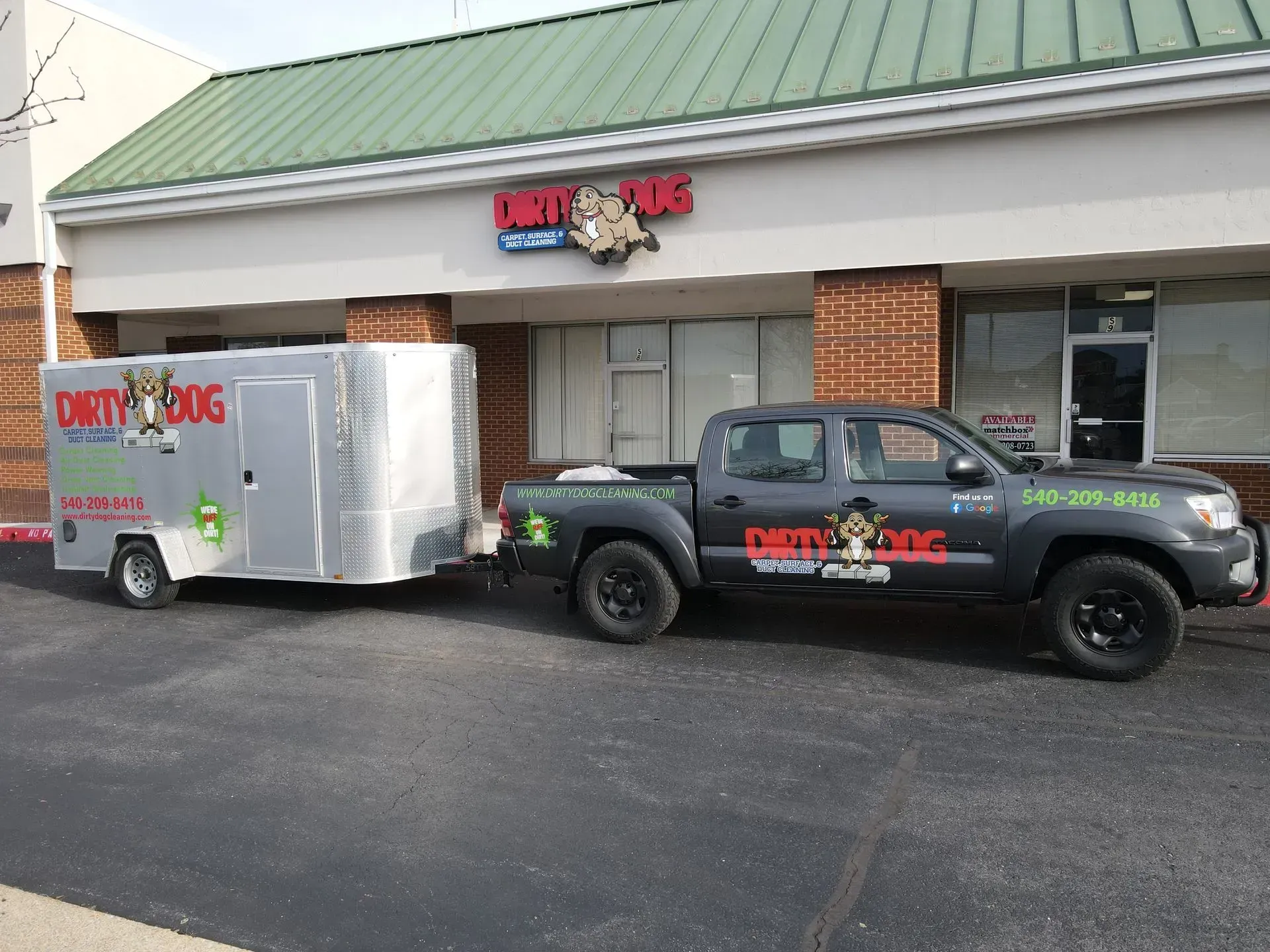 Branded pickup and enclosed trailer parked outside a strip mall storefront, advertising a cleaning service.