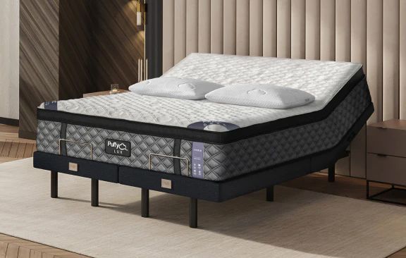 Adjustable bed with mattress and pillows in a bedroom setting.