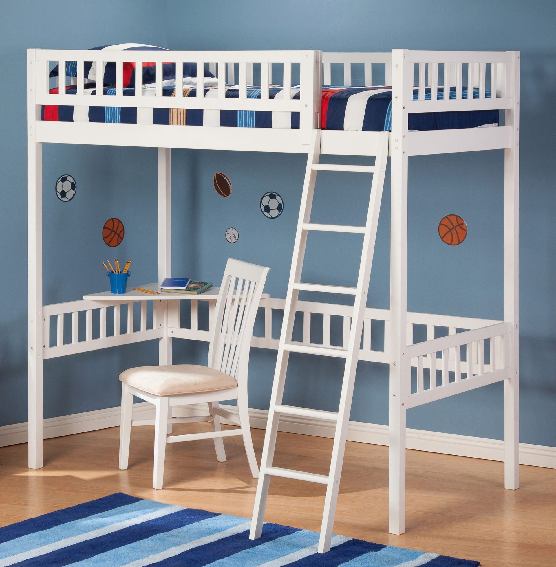 White loft bed with desk and ladder on blue wall with sports decals.