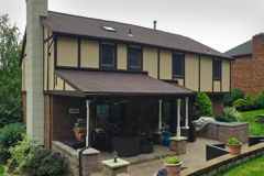 A house with a patio and awning on the side of it.
