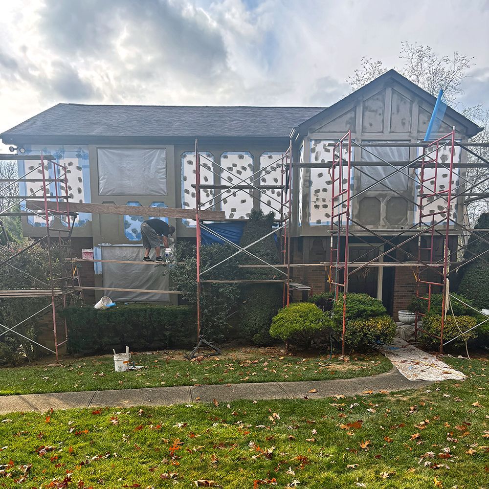A house is being painted with scaffolding around it