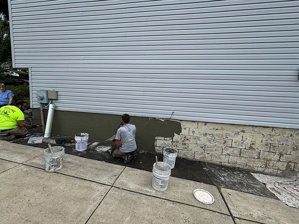 A group of people are painting the side of a house.