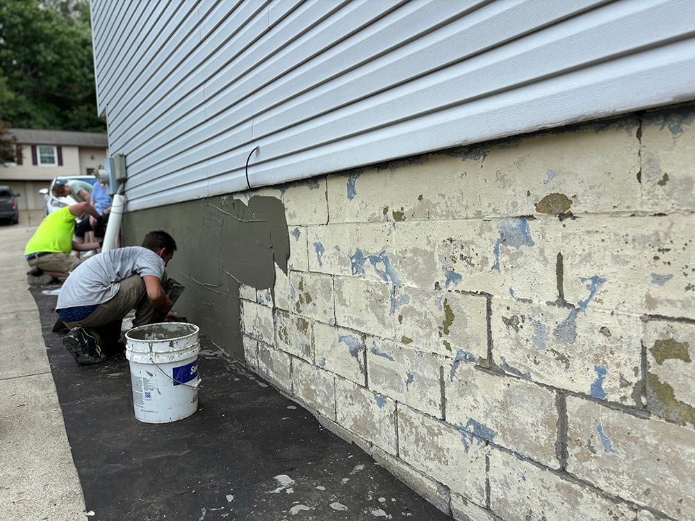A group of people are working on the side of a building.