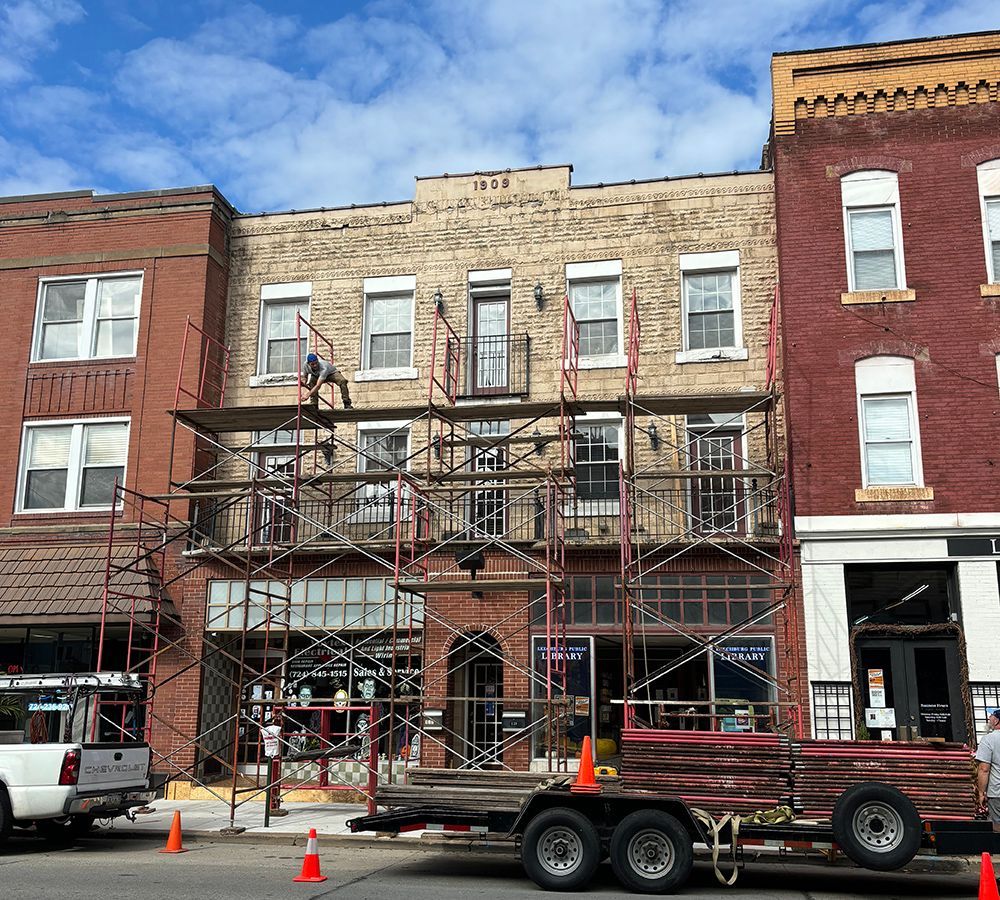 A truck is parked in front of a building with scaffolding on it