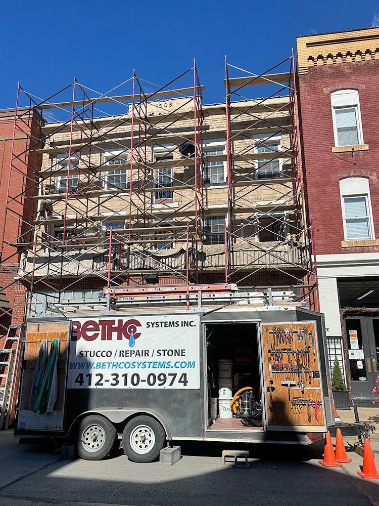 A trailer is parked in front of a building with scaffolding on it.