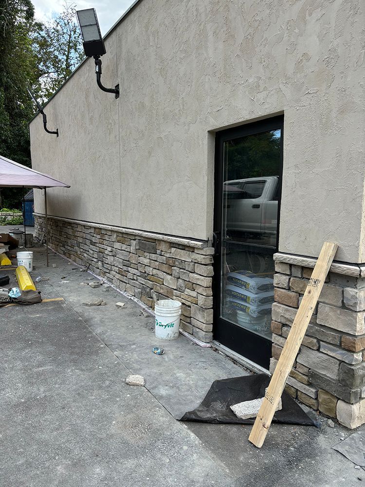 A stone wall is being built on the side of a building.