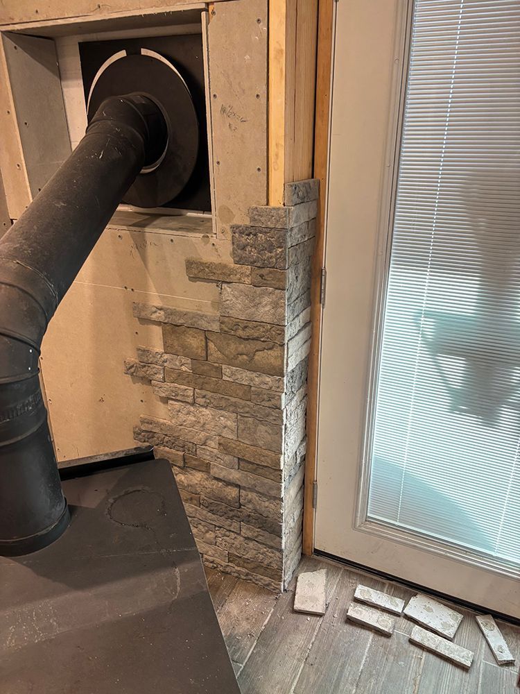 A fireplace is being built in a room next to a door.