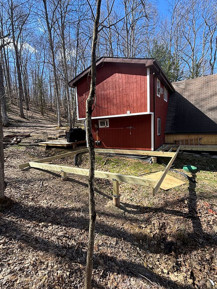 A red barn is sitting in the middle of a forest.