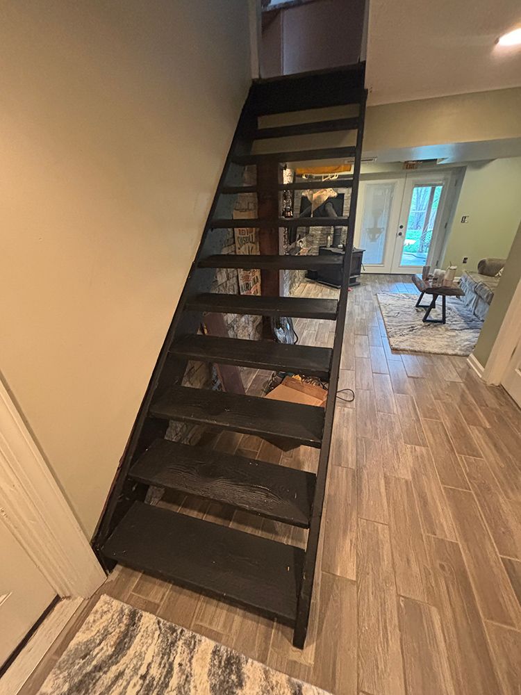 A black staircase leading up to the second floor of a house.