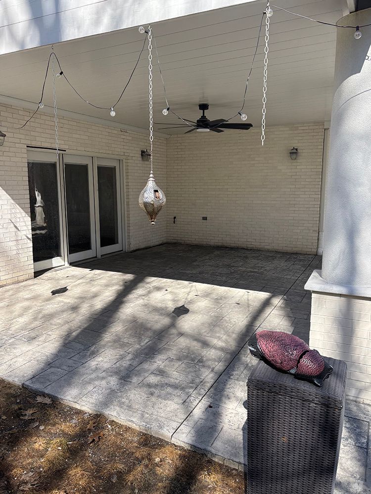 A patio with a ceiling fan and a lantern hanging from the ceiling.