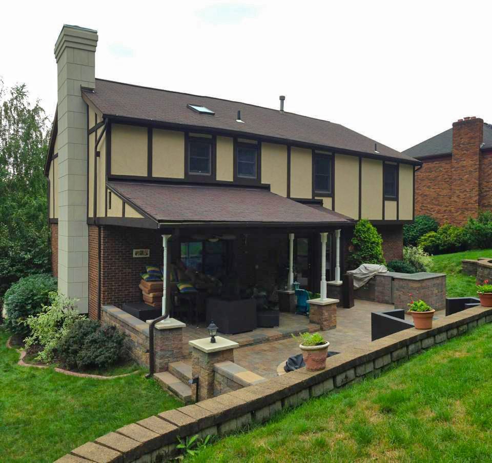 A house with a patio and a brick wall in front of it