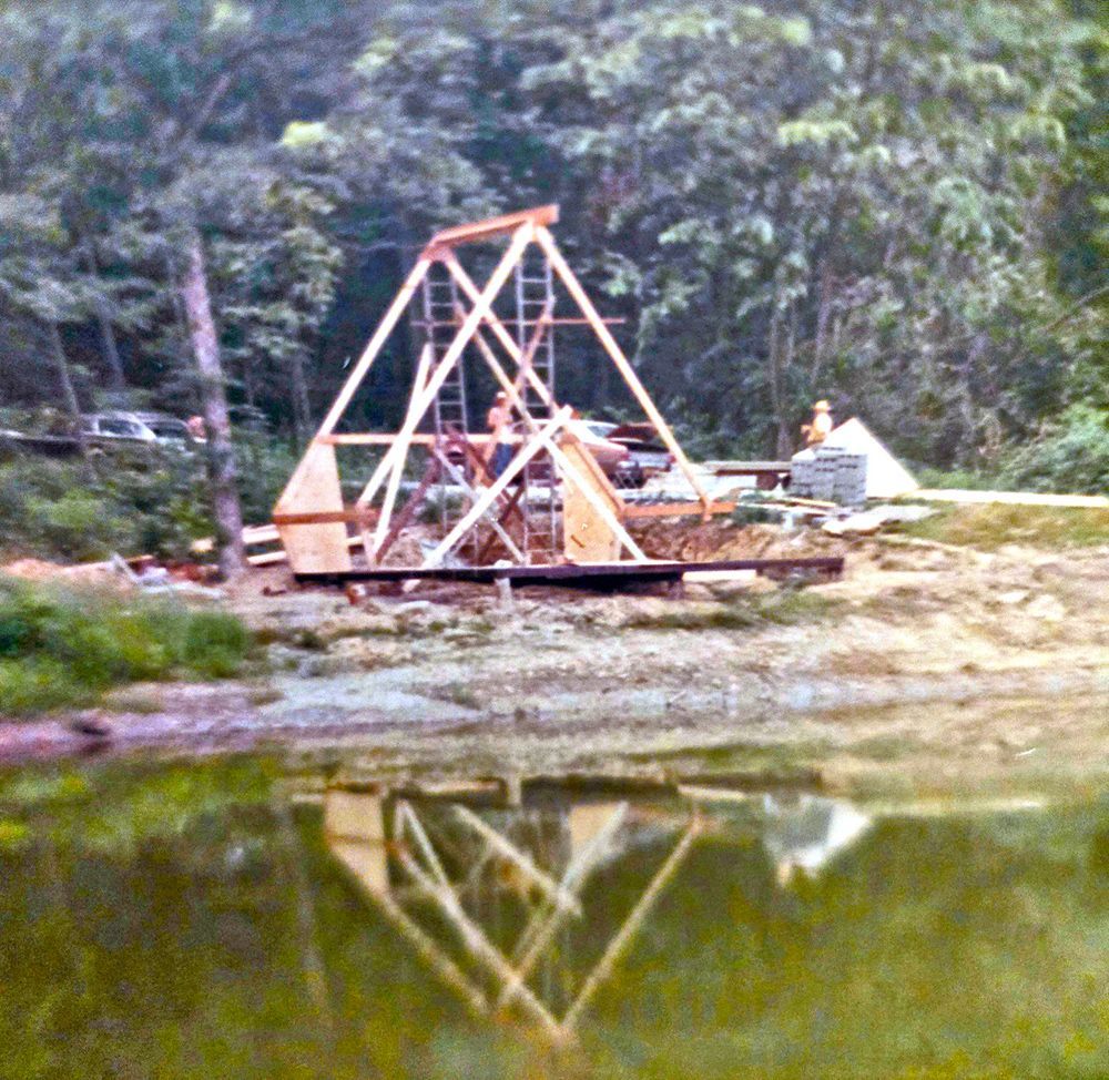 A wooden structure is being built next to a body of water