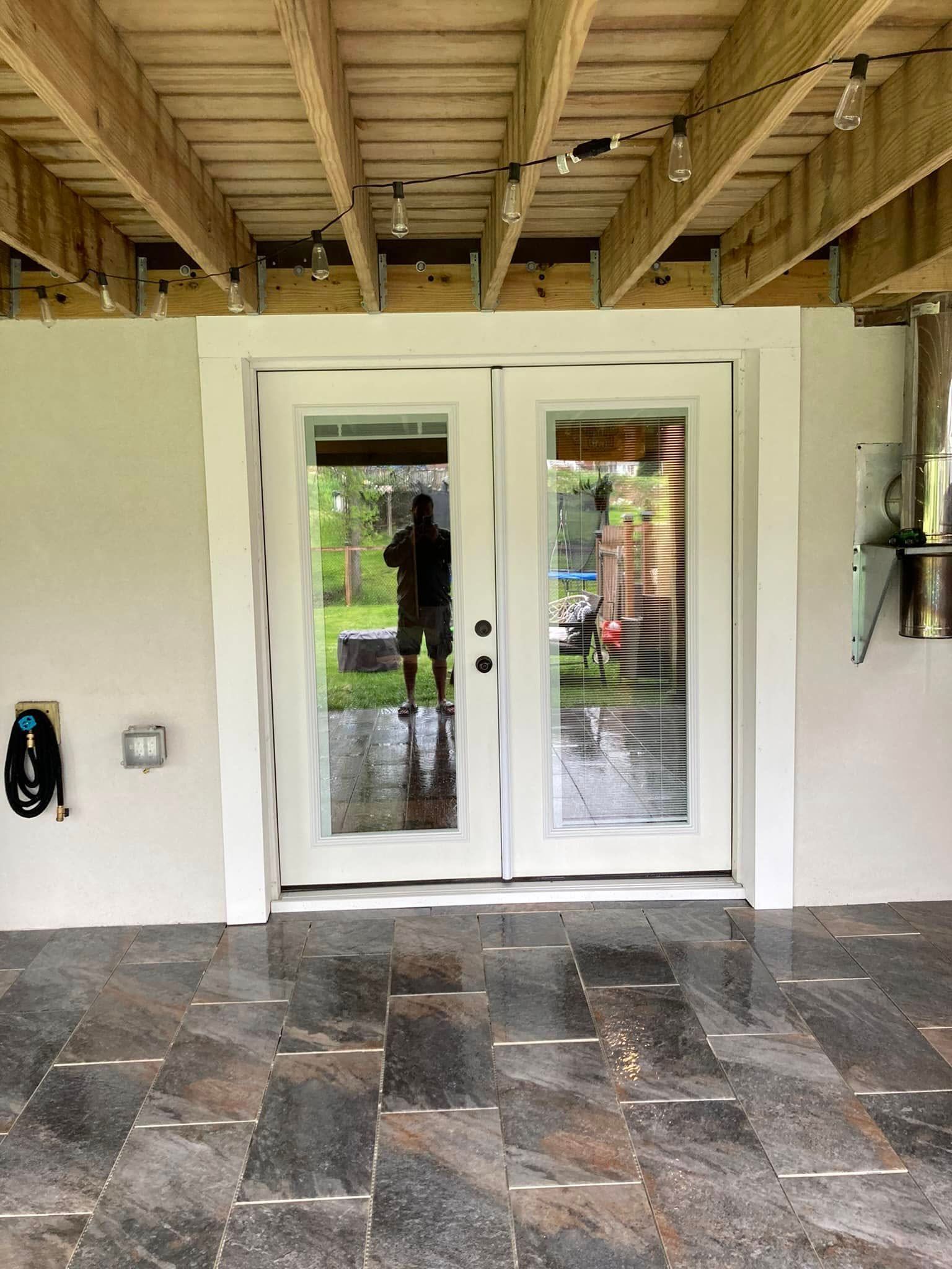 There is a reflection of a person in the doorway of a house.