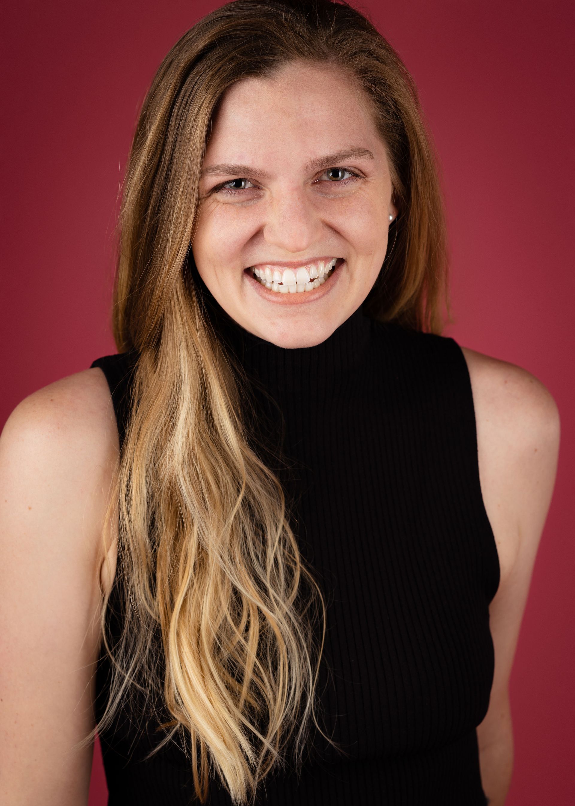 Gabrielle Encarnacion, The woman is wearing a black turtleneck and smiling for the camera.