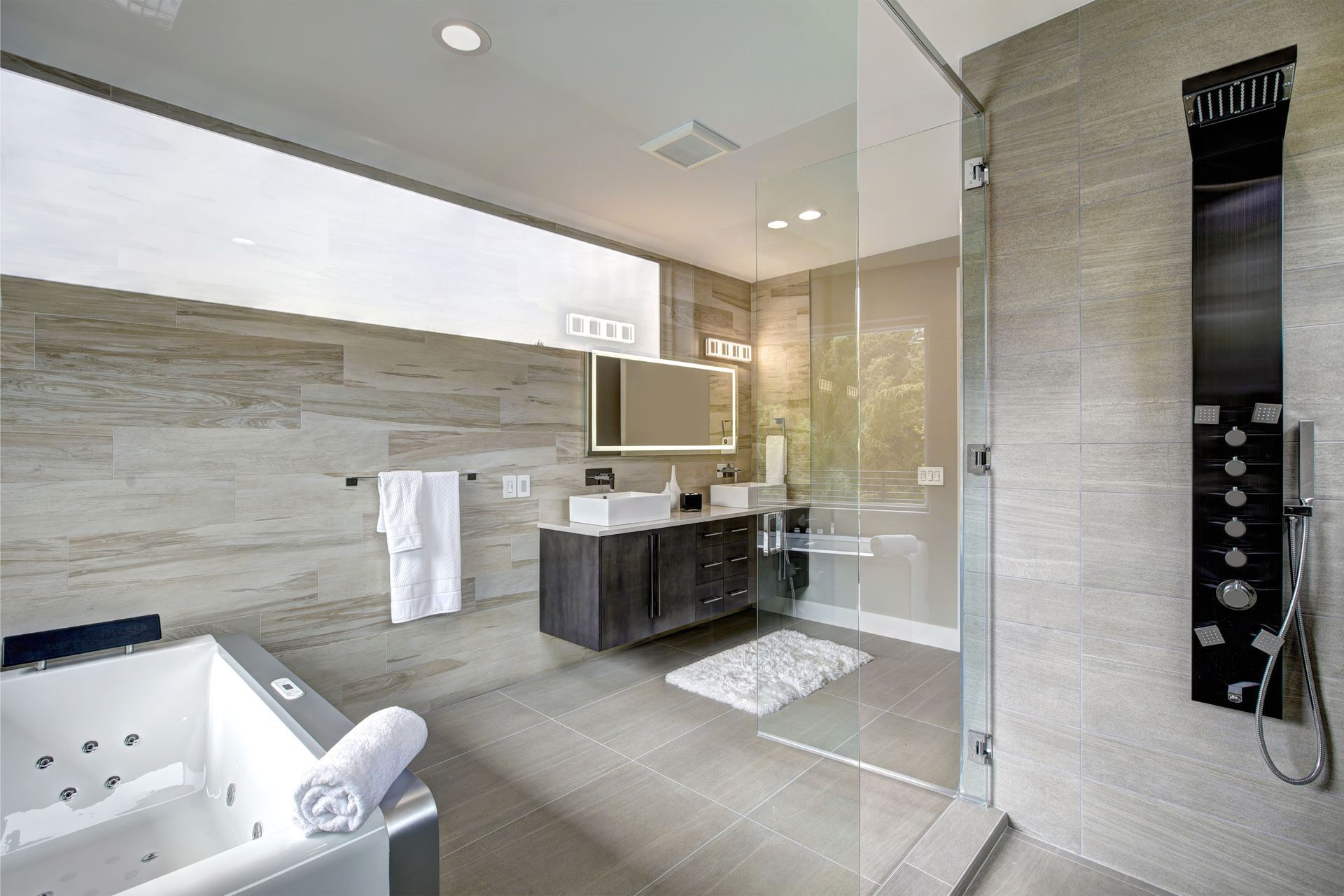 Modern bathroom with tub, shower, and dark wood vanity; gray and white color scheme.
