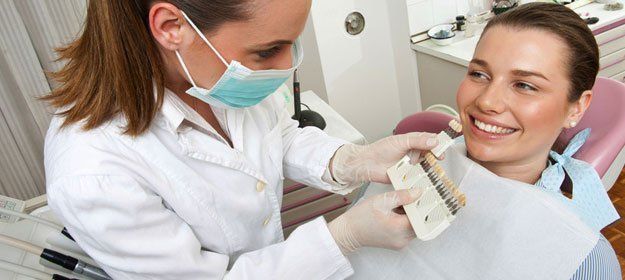 Dentist showing different veneers to patient