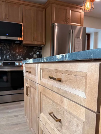 Kitchen with light wood cabinets, stainless steel appliances, and a blue countertop.