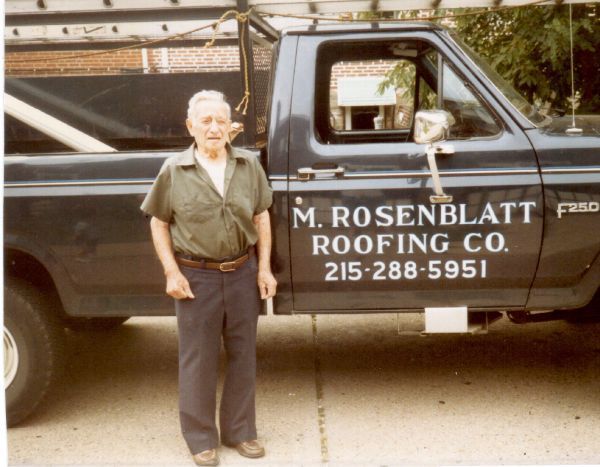 A man standing in front of a m. rosenblatt roofing company truck