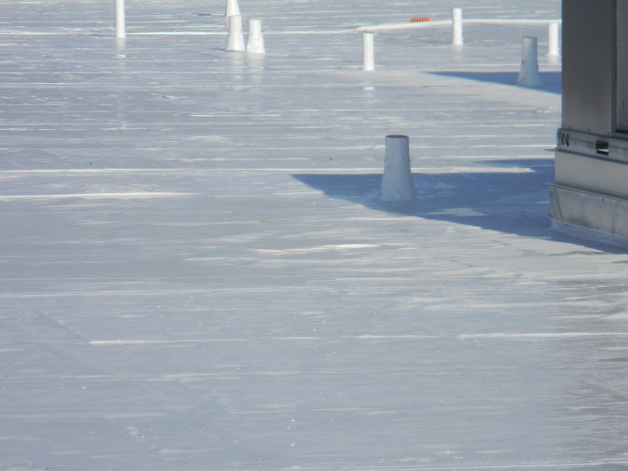 A gray concrete floor with a few white pipes on it.
