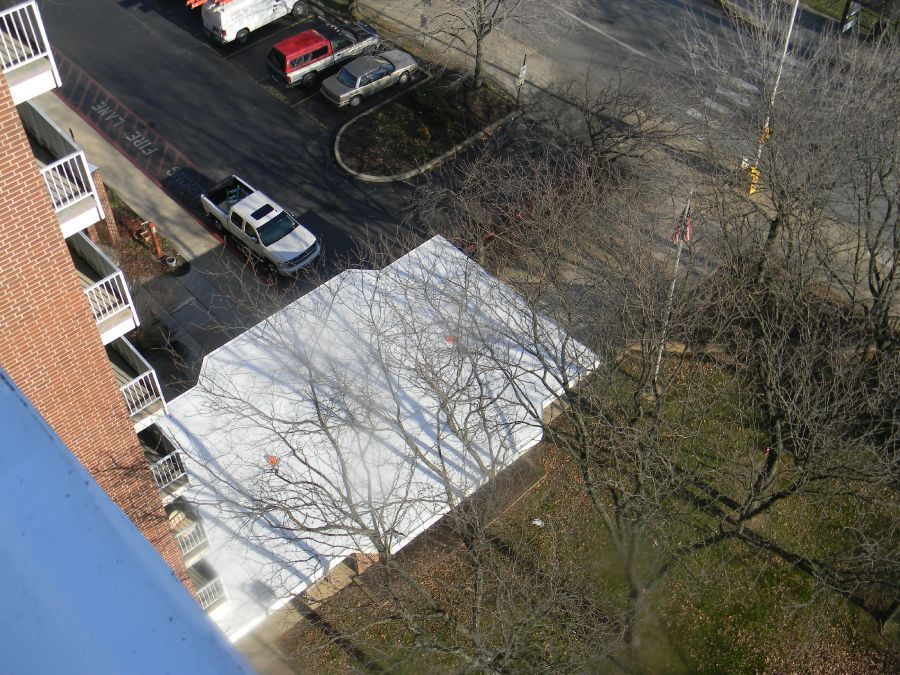 An aerial view of a parking lot with cars parked in front of a building
