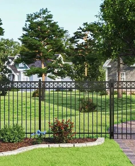 Black metal fence in front of a green lawn and suburban houses, with trees and a brick walkway