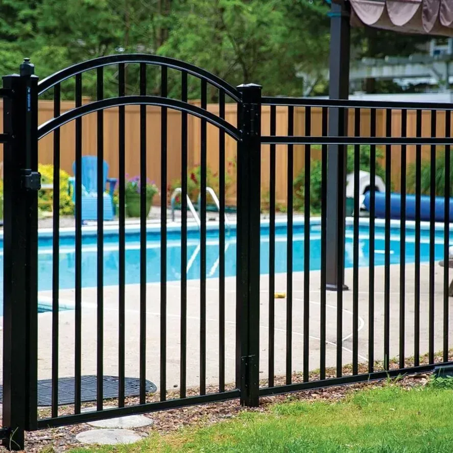 Black metal fence beside a blue swimming pool in a backyard setting