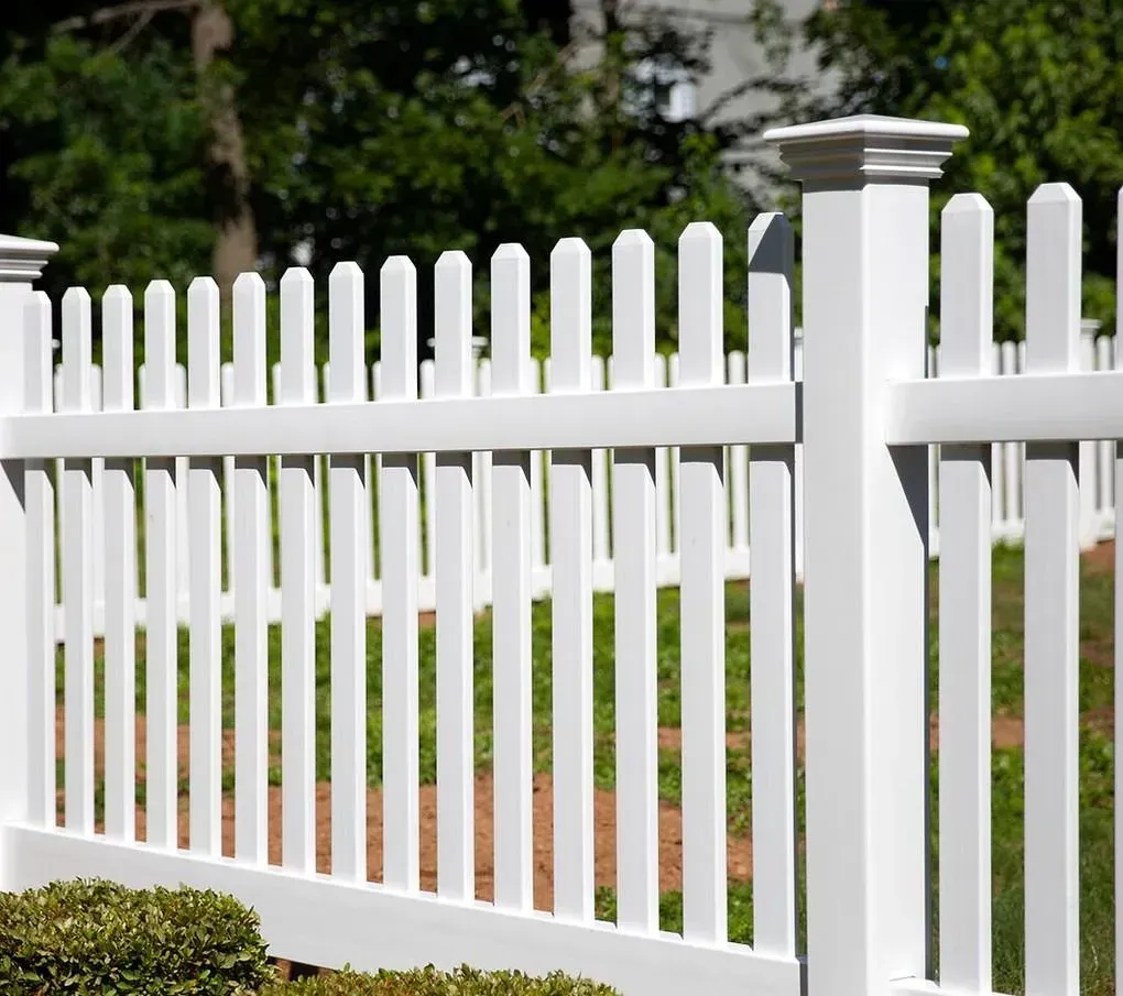 White picket fence with square posts in a green yard