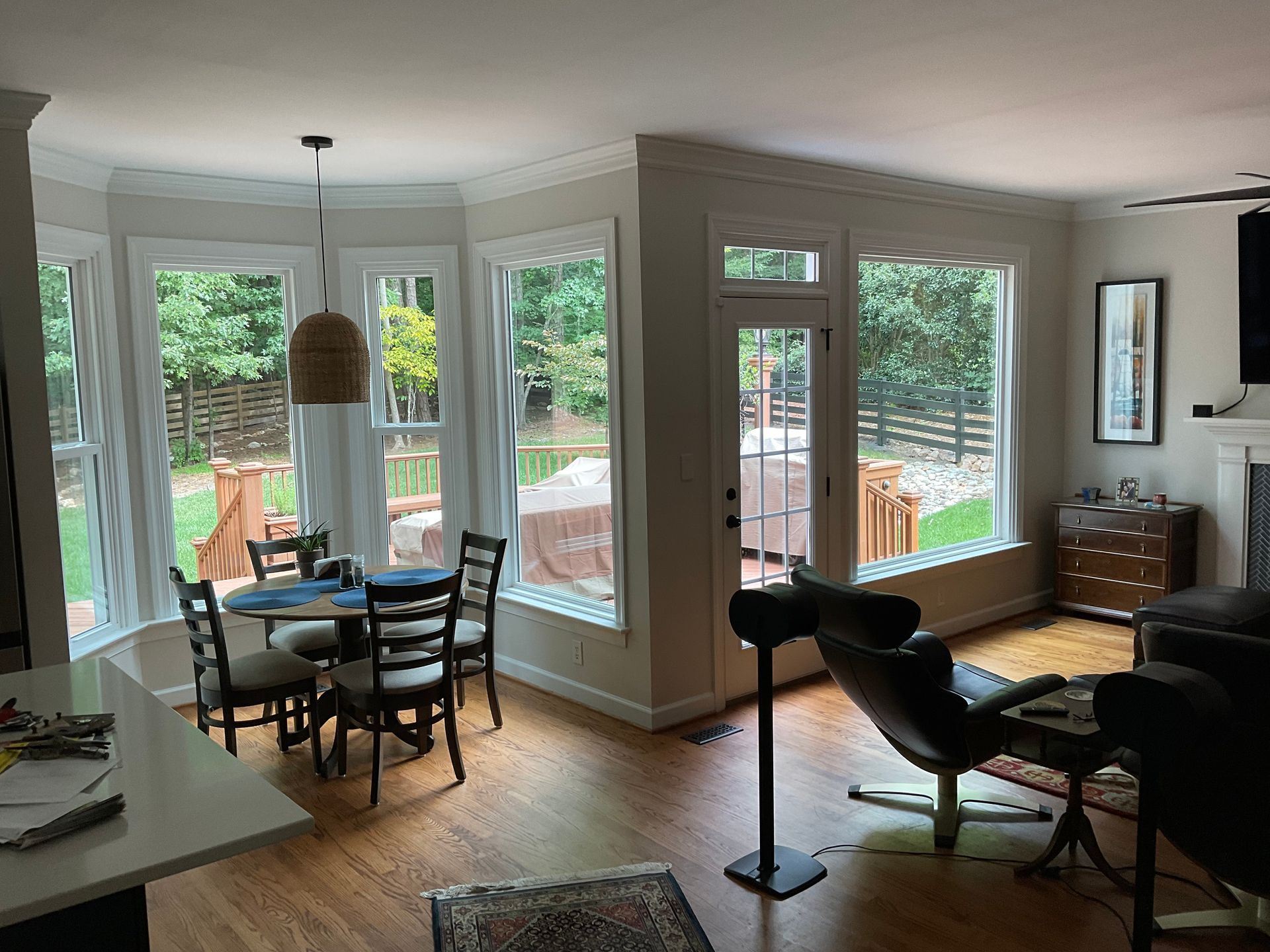 A bright, open dining and living space with floor-to-ceiling windows and outdoor views.