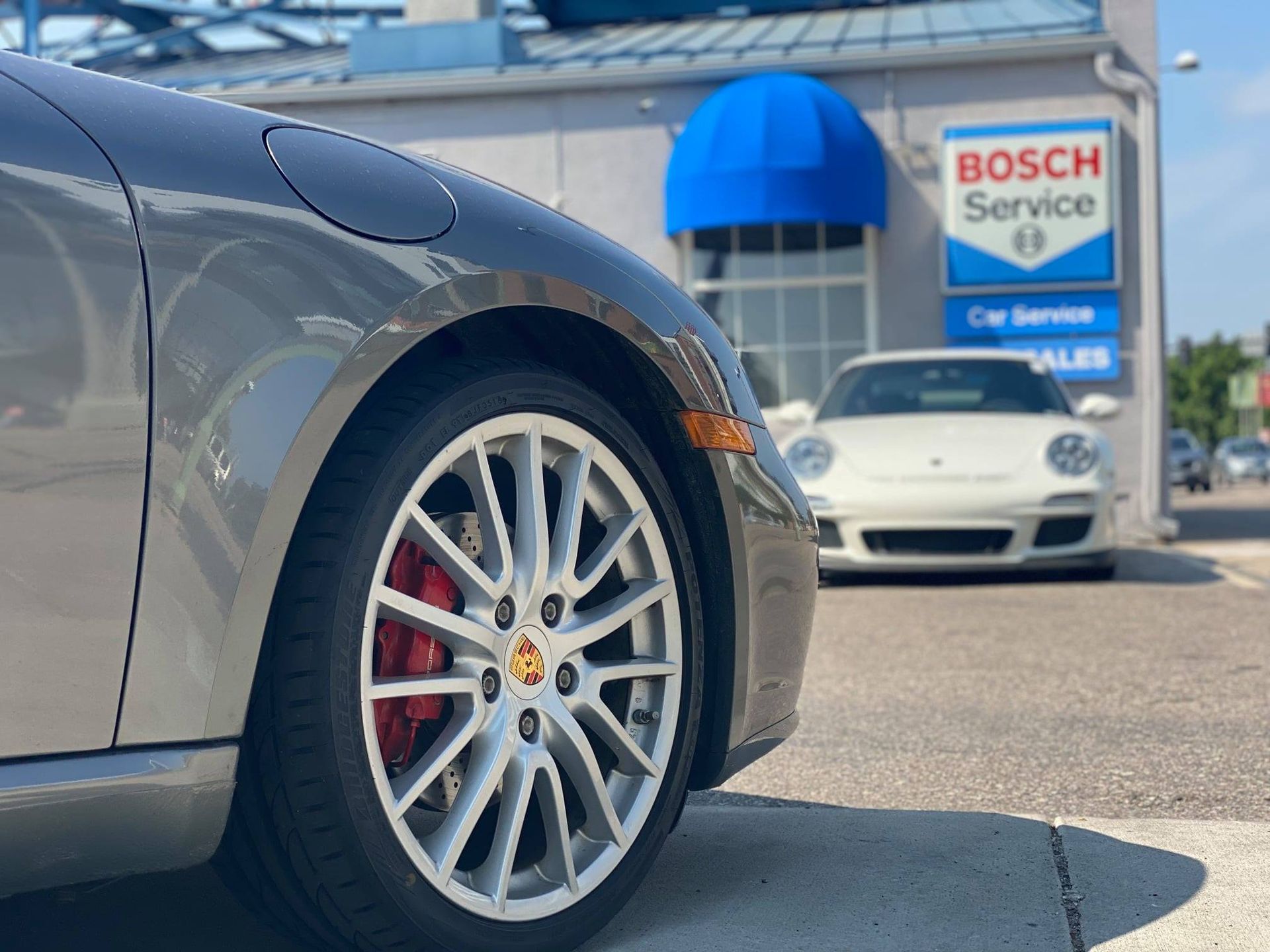 A car is parked in front of a bosch service building