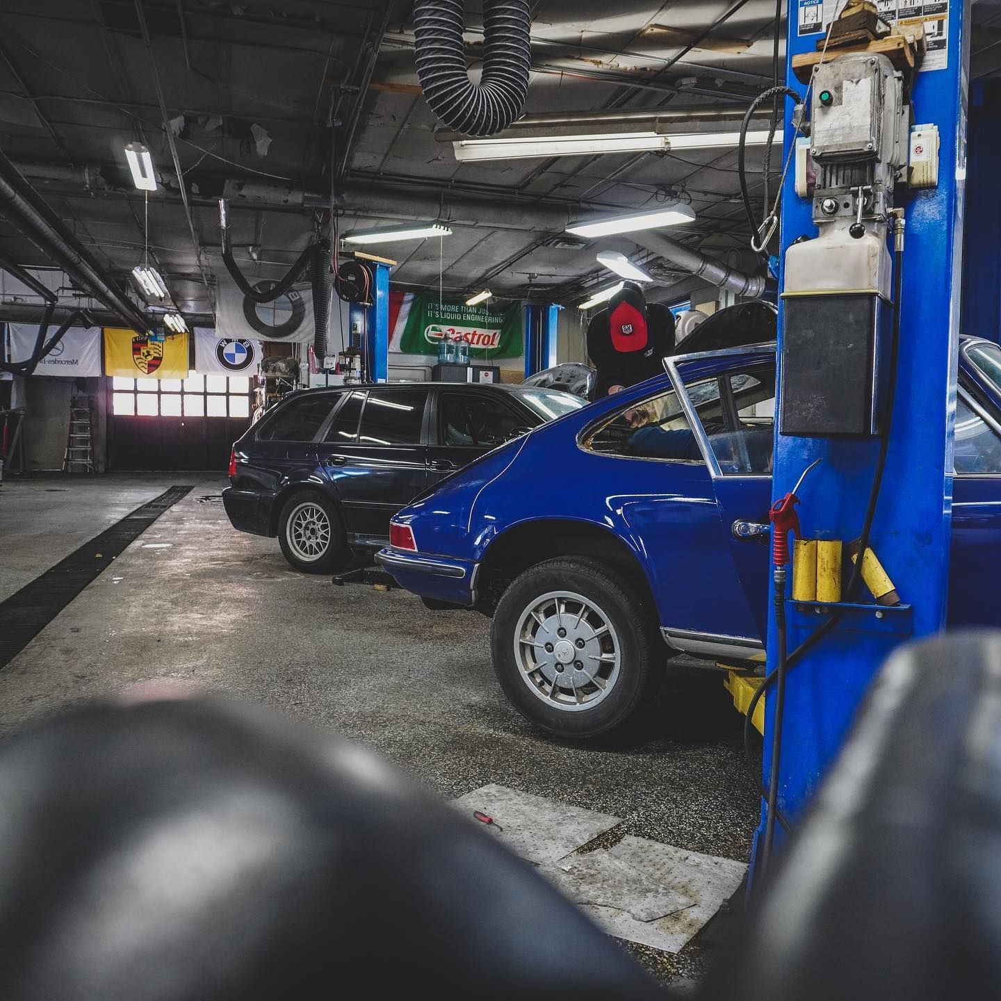 A row of blue cars are parked in a garage