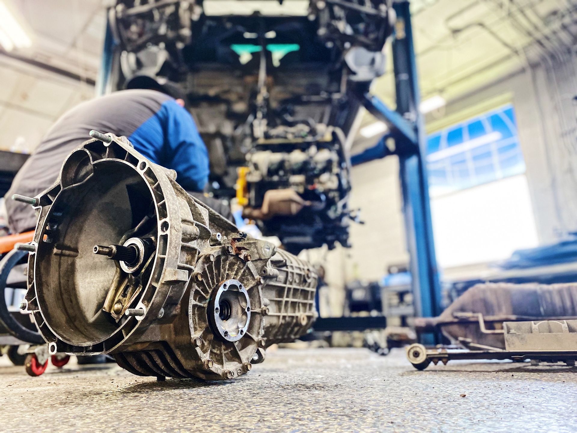 A man is working on a car engine in a garage.