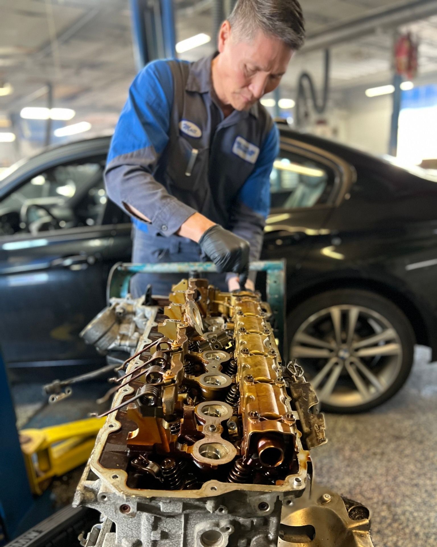 A man is working on a car engine in a garage.