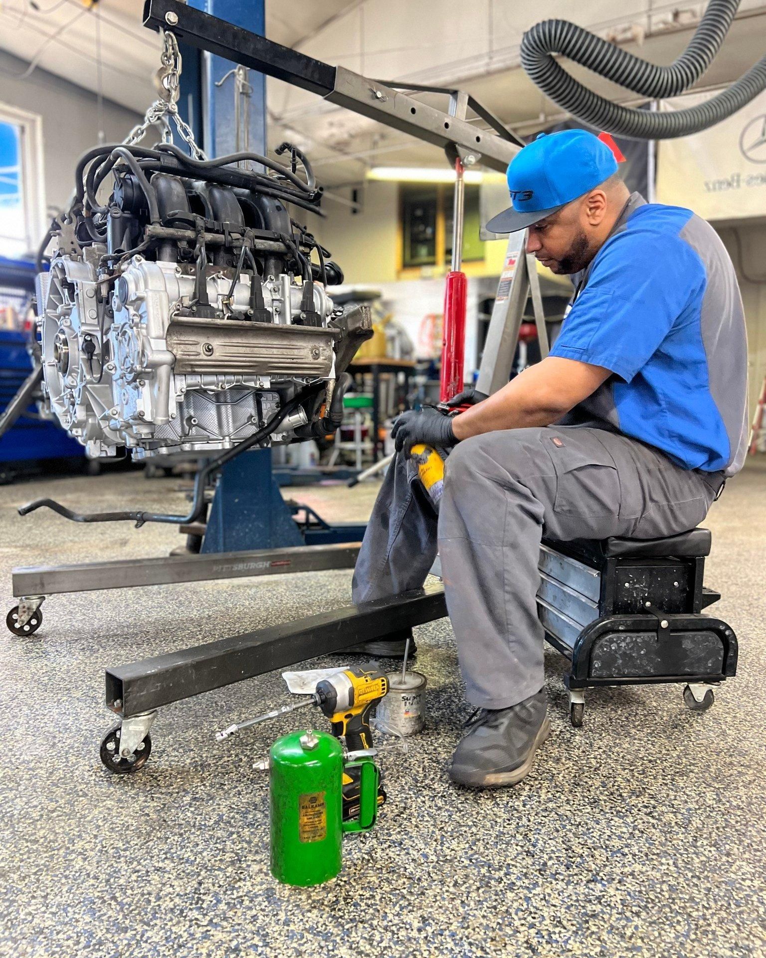 A man is working on a car engine in a garage.
