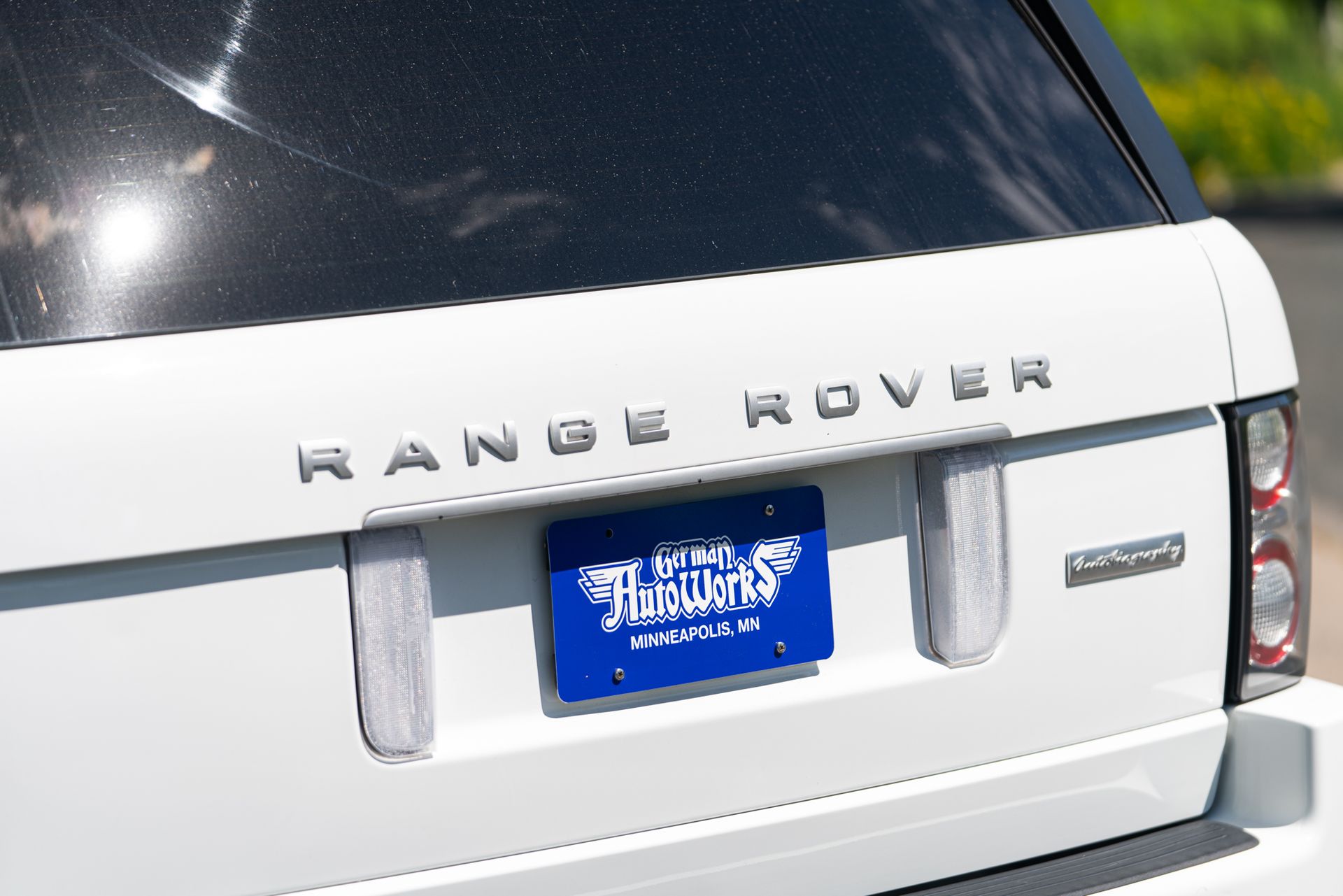 A white range rover with a blue license plate