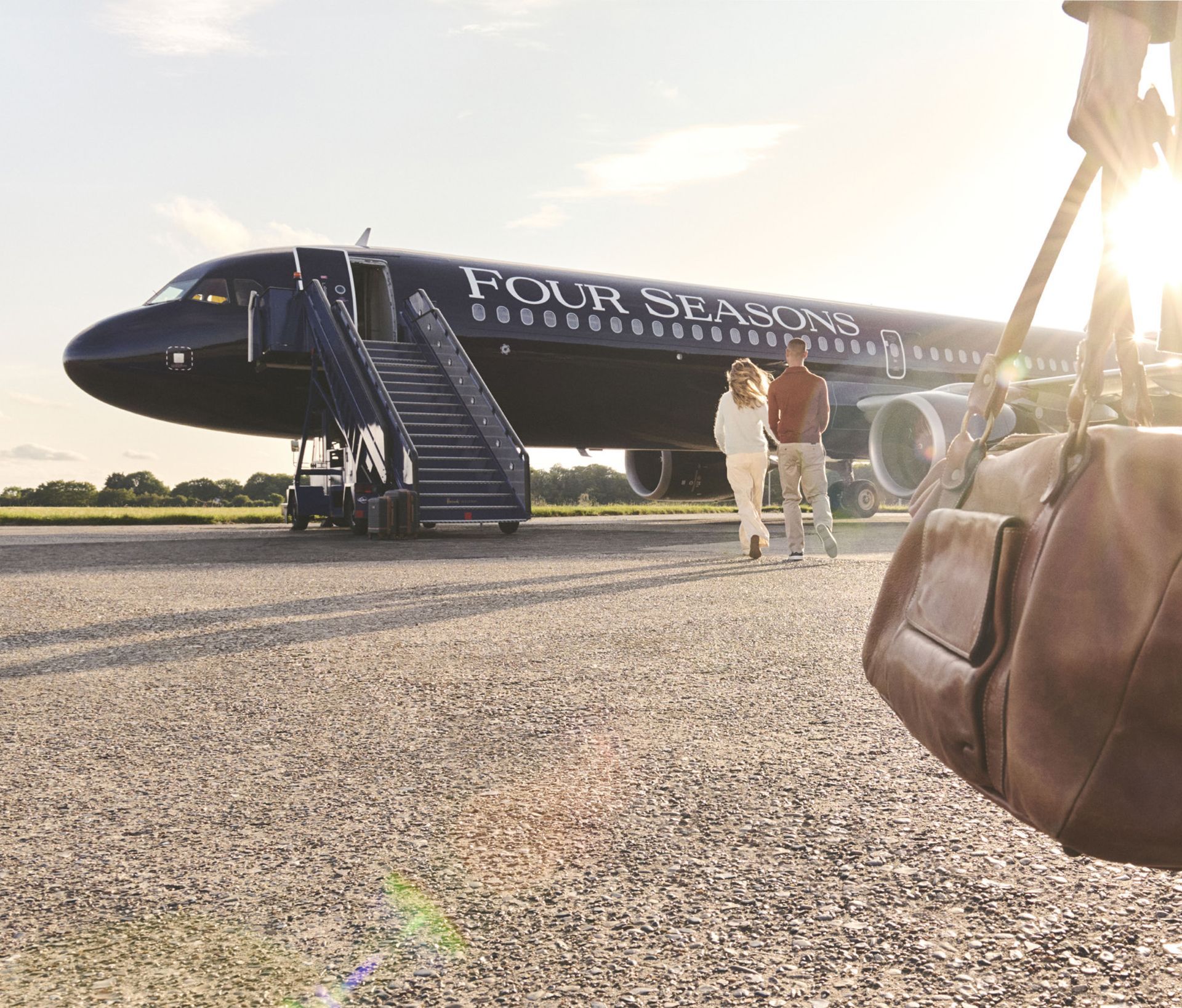 A four seasons airplane is parked on the runway