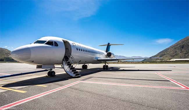 A private jet is parked on the tarmac at an airport.