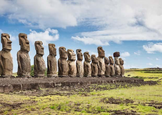 A row of statues standing next to each other in a field.