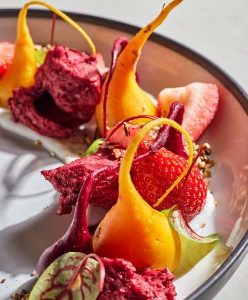 A close up of a plate of food with strawberries and beets