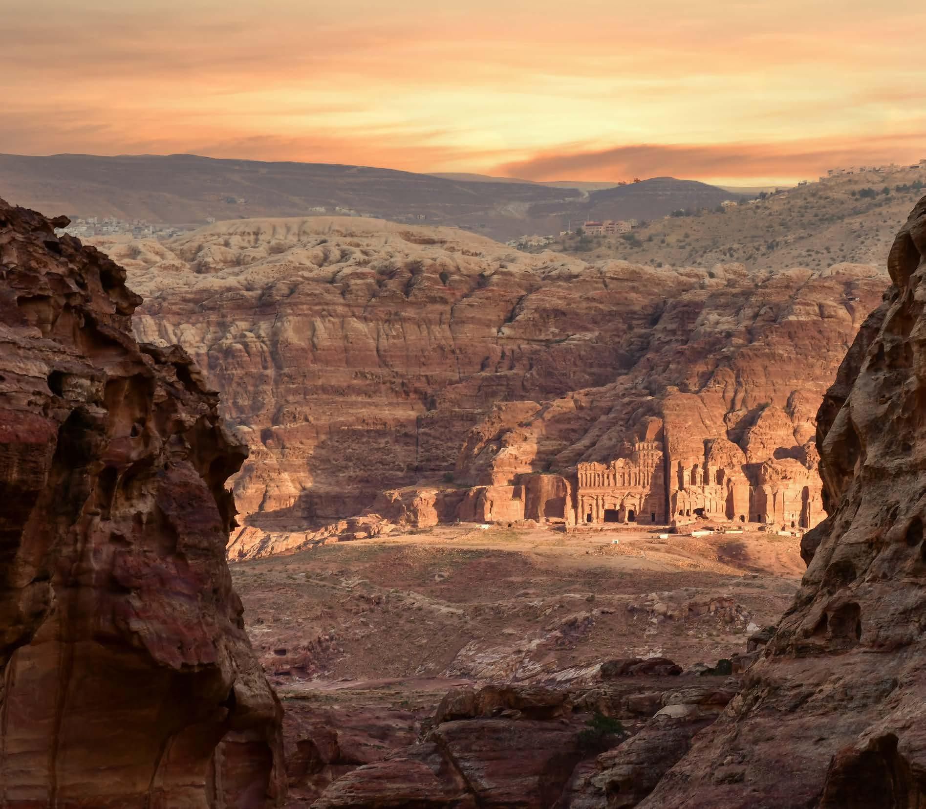 A view of a city from between two rocks at sunset.