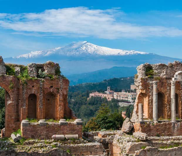 A ruined building with a mountain in the background.