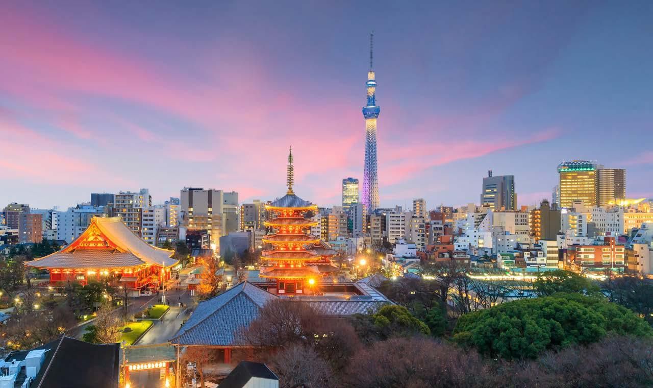An aerial view of a city skyline at night with a tower in the foreground.