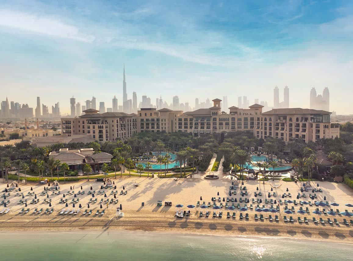 An aerial view of a beach with a large building in the background.