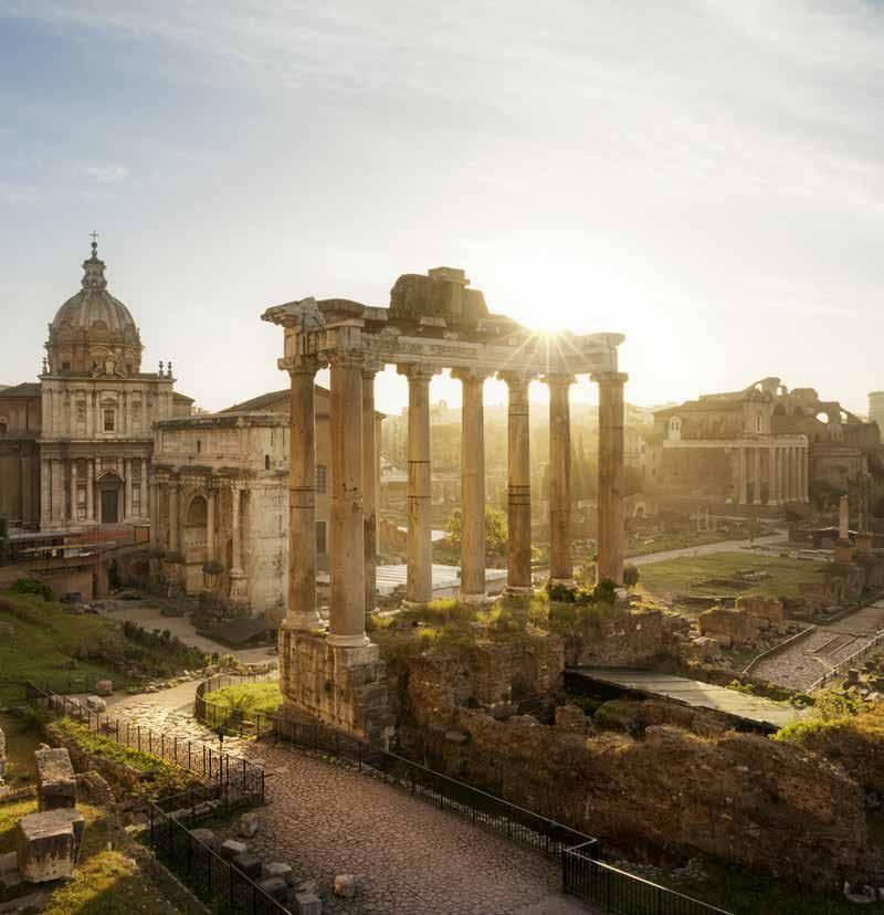 The sun is shining through the columns of the roman forum.
