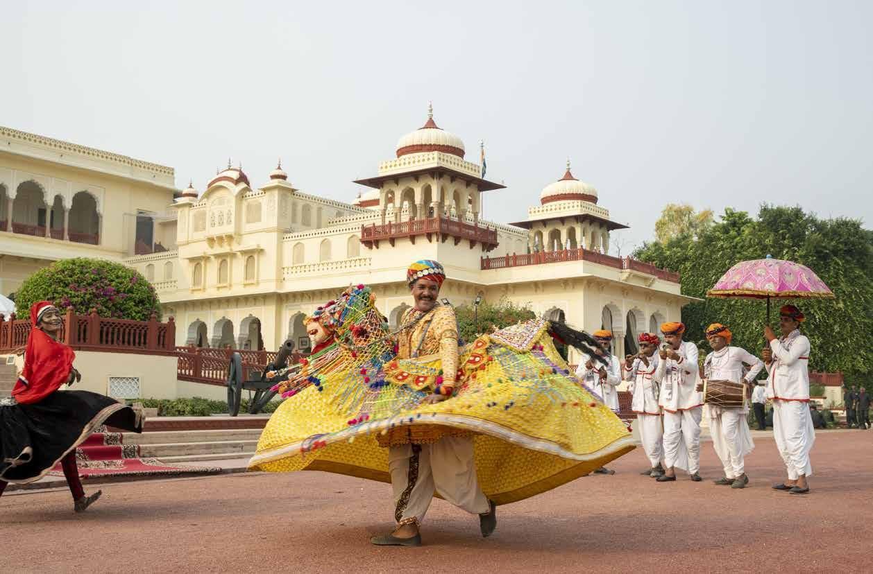 A group of people are dancing in front of a building.