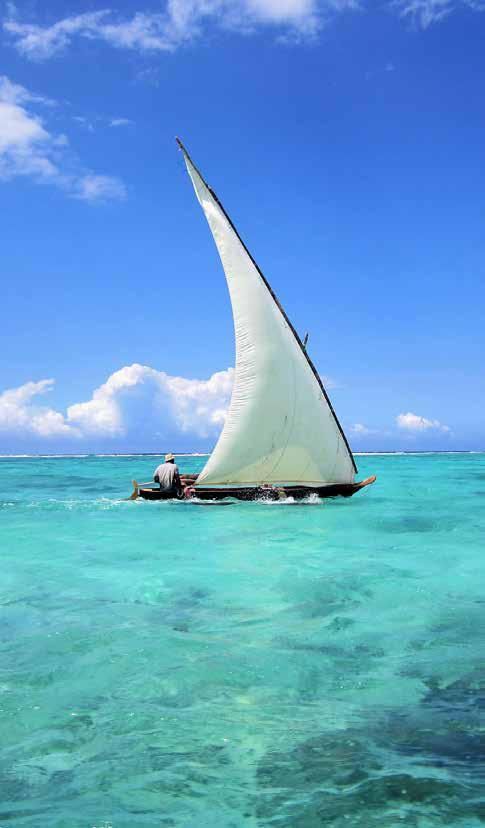 A sailboat is floating on top of a turquoise ocean.
