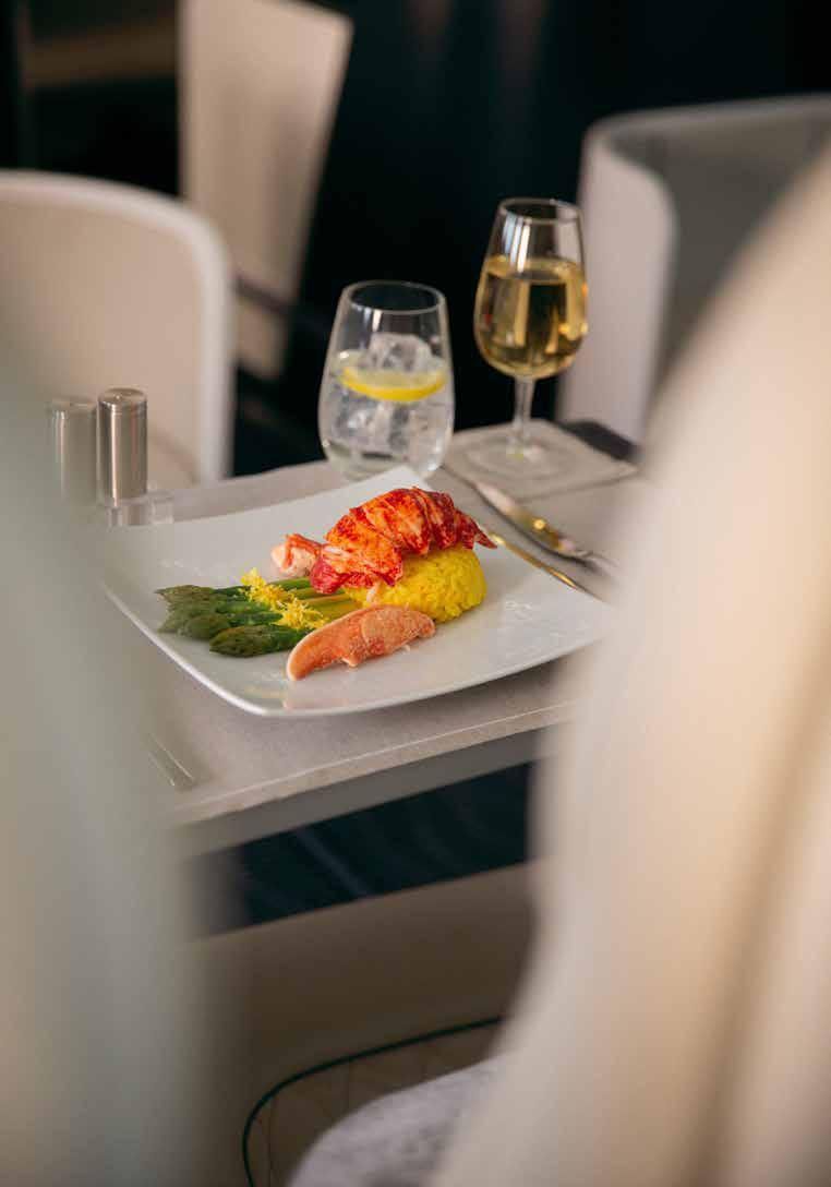 A plate of food and a glass of wine on a table.