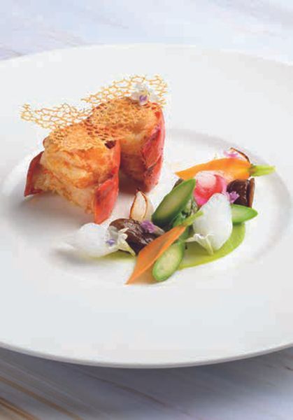 A white plate topped with a piece of meat and vegetables.