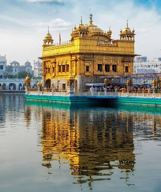 The golden temple is reflected in the water.